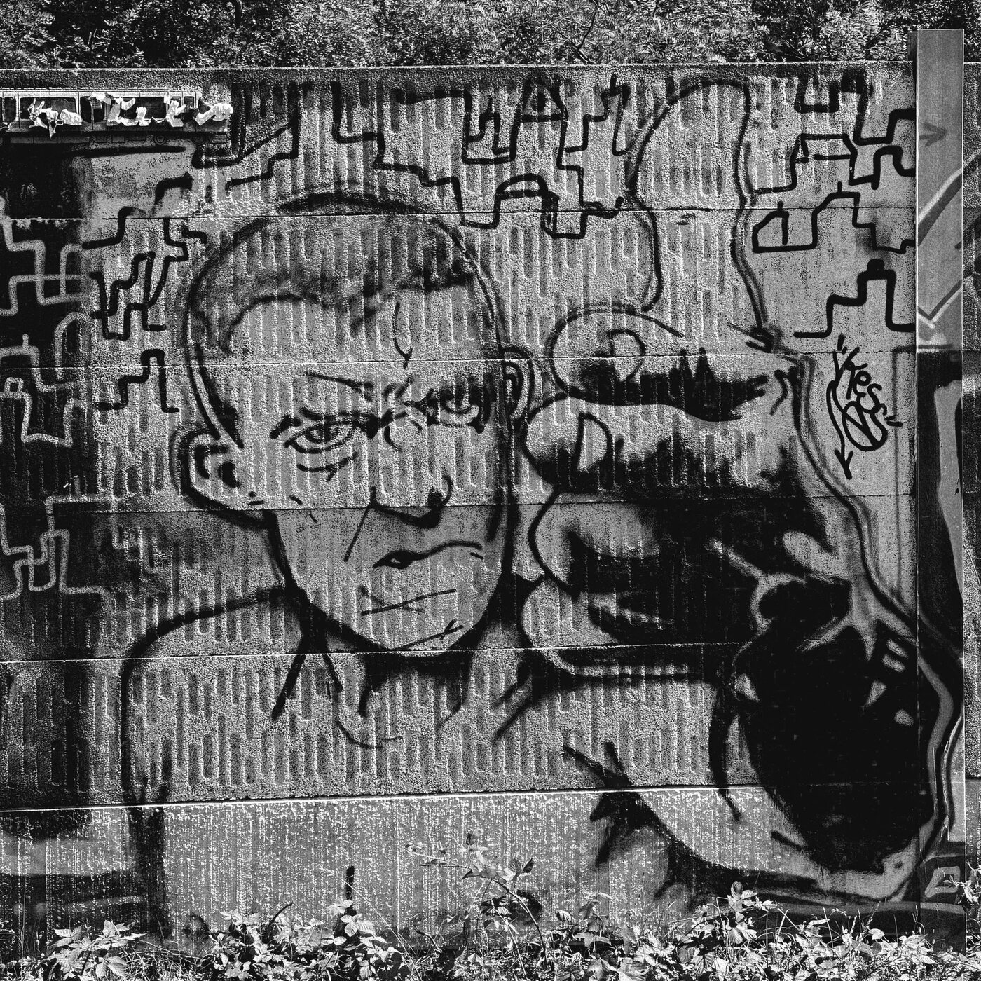 Two painted faces on a weathered urban wall