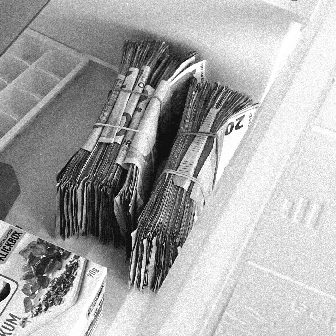 Bundles of euro banknotes stored in a plastic container